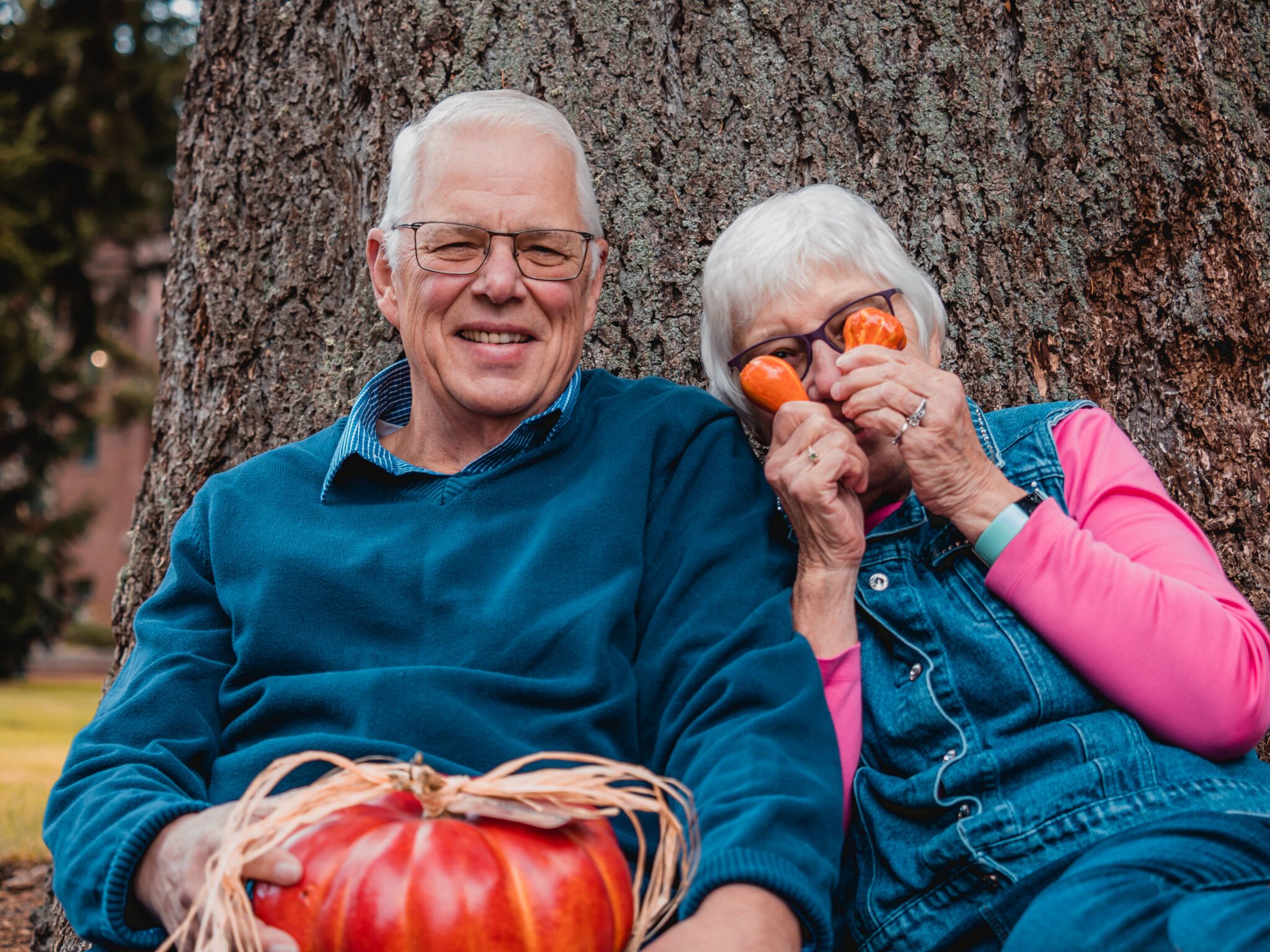 Older couple holding a pumpkin outdoors